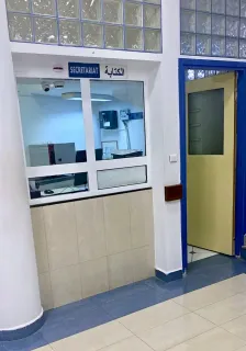 Guichet du secrétariat du centre, avec une porte à encadrement bleu.